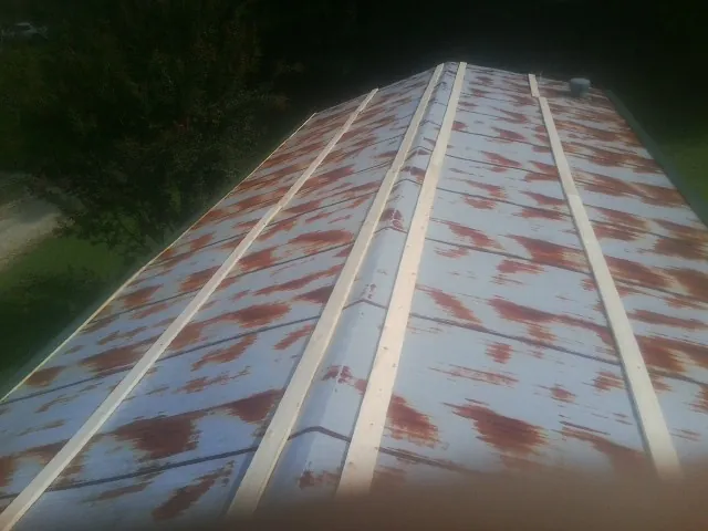 Rusted metal roof panels with new wood purlins before replacement — Storm Damage Roof Repair in Putney by Roofing Brothers